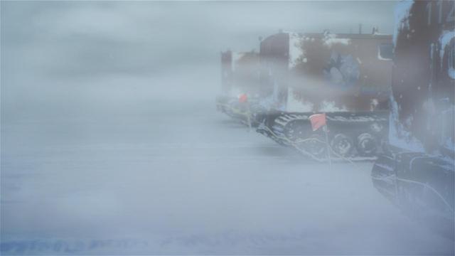 Three orange Sno-Cats with their large tank treds are visible on the right hand of the frame looking down the line. Everywhere else is snow, ice, and gusty, wind-blown blizzard conditions!